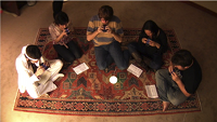 five people sit on rug each playing Ocarina on iPhones